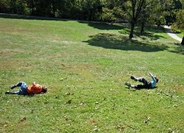 kids rolling on hill